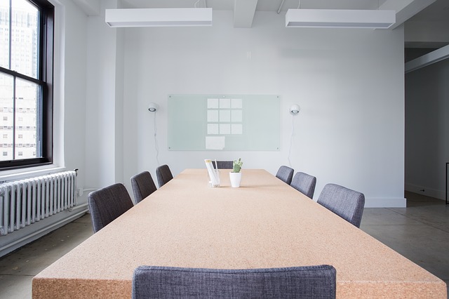 velký stůl, šedé židle, konferenční místnost
